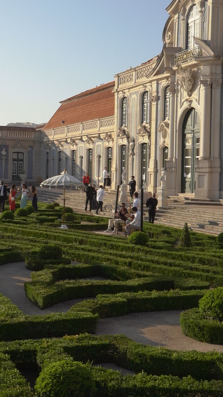 Elegantes Destination-Hochzeitspaar auf einer sonnigen Terrasse mit Blick auf die portugiesische Küste